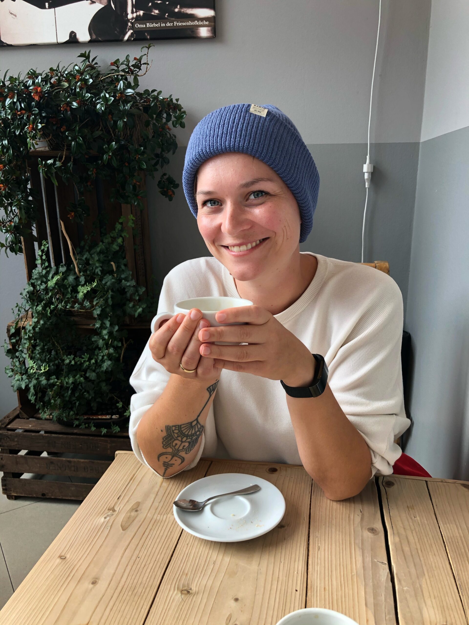 Anna im Café mit einem Kaffee in der Hand